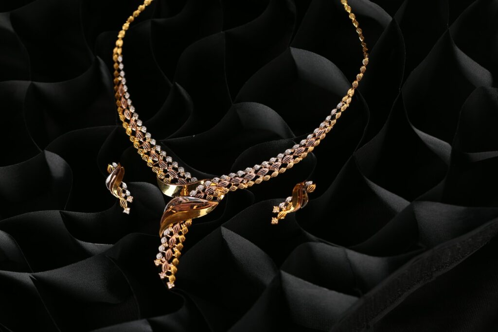 A gold neckless resting on black silk