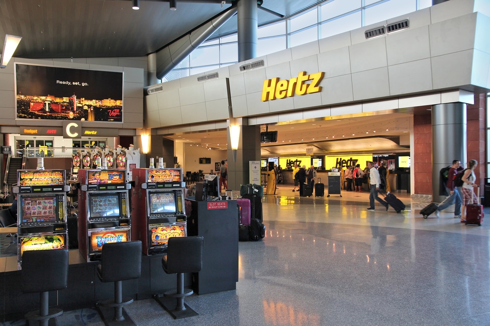 Image of a Hertz car rental counter in McCarran Airport with slot machines