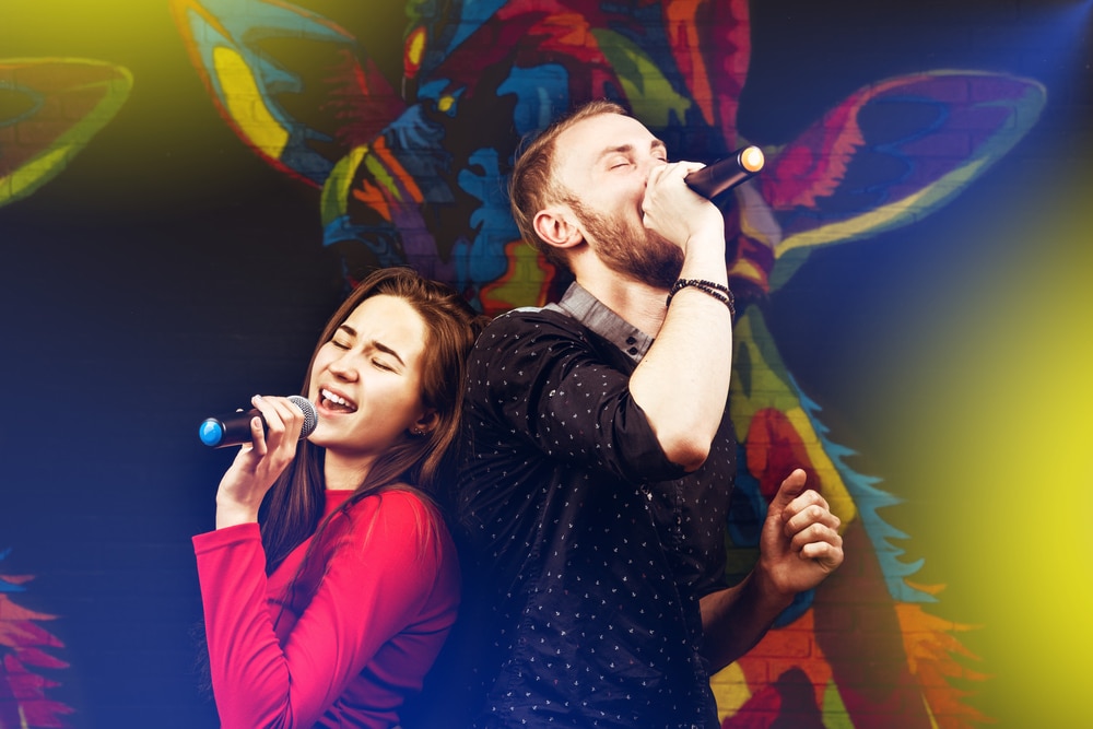 Image of happy couple singing in a karaoke night club