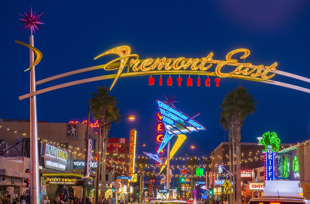 Image of Fremont East neon sign at dusk with many people coming from activities on the Strip