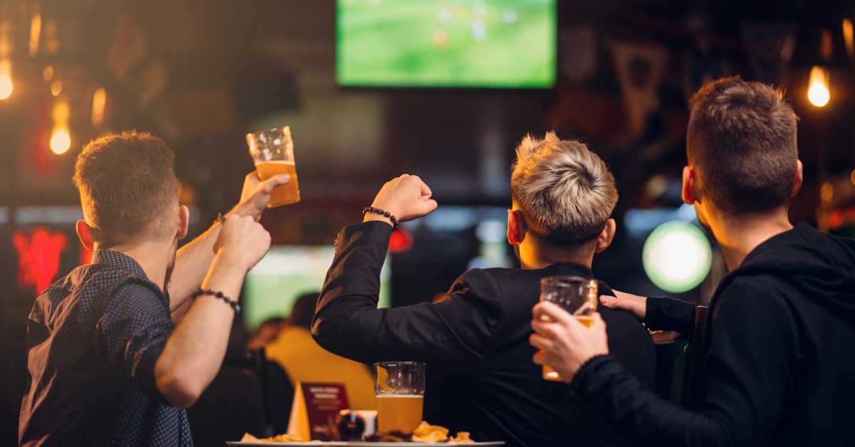 Image of three men watching a game at a sports bar