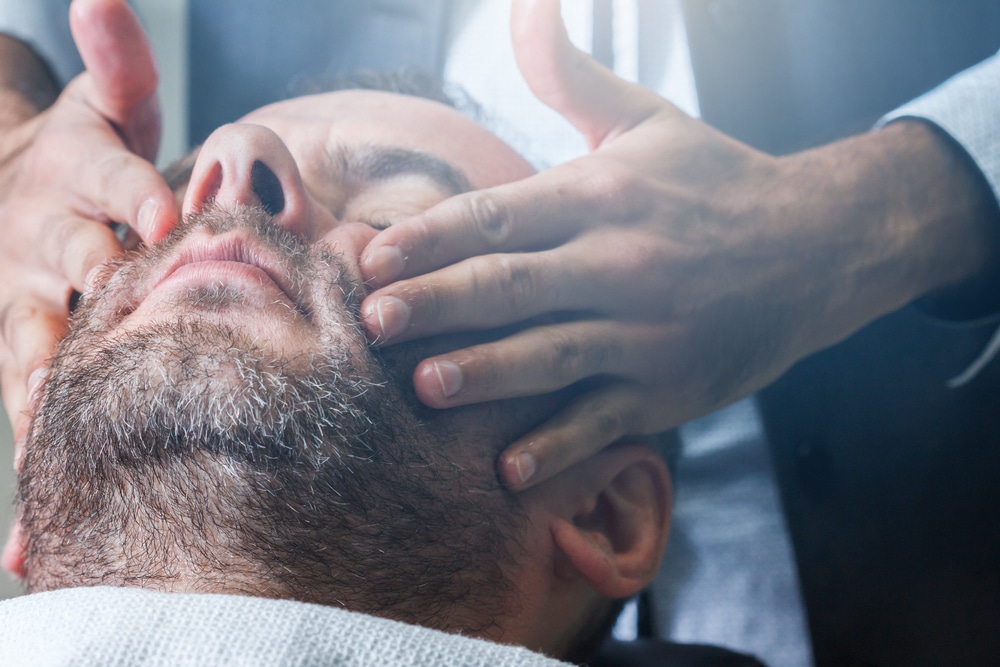 Man getting beard groomed and massaged 