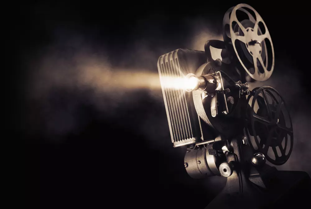 Movie projector on a dark background with light beam / high contrast image