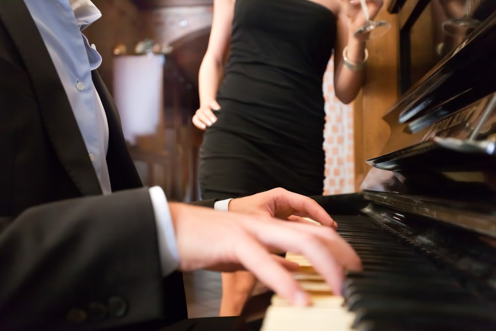 Man playing piano for a woman at a piano bar