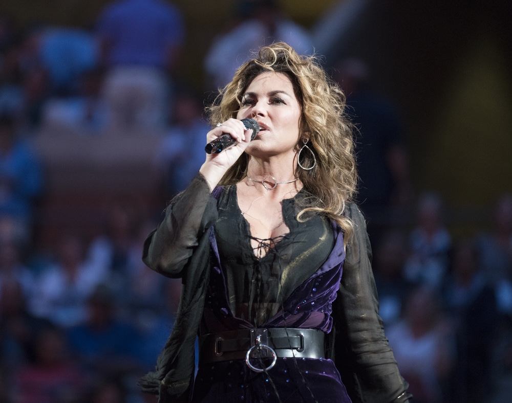 Shania Twain performing live in an all black and purple costume