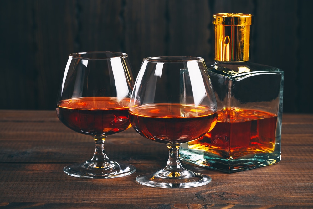 Glasses of brandy or cognac on a wooden table
