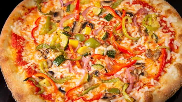 up close image of a pizza from slice of vegas with vegetables 