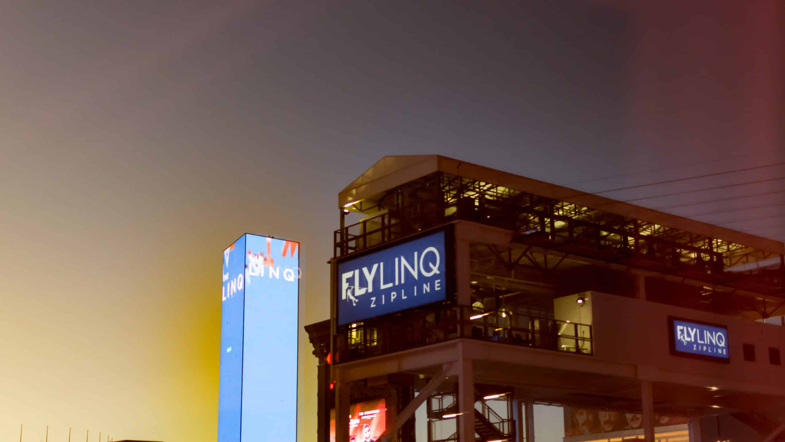Fly LINQ zipline sign and building at dusk