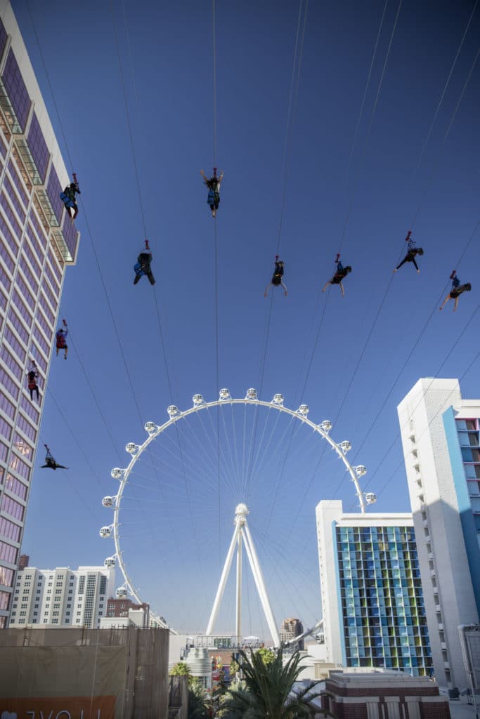 long shot of several people on the fly LINQ zipline