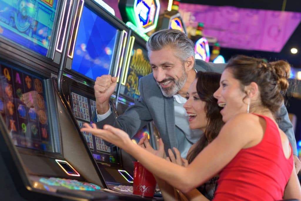 people celebrating around a slot machine