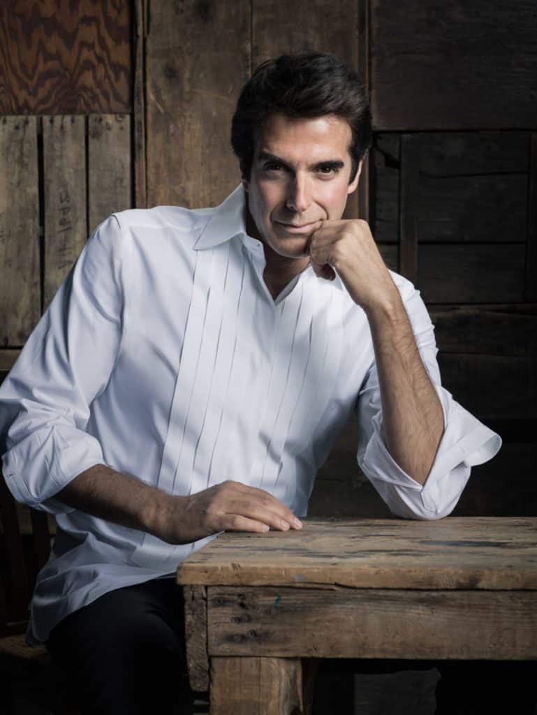 David Copperfield leaning against a table