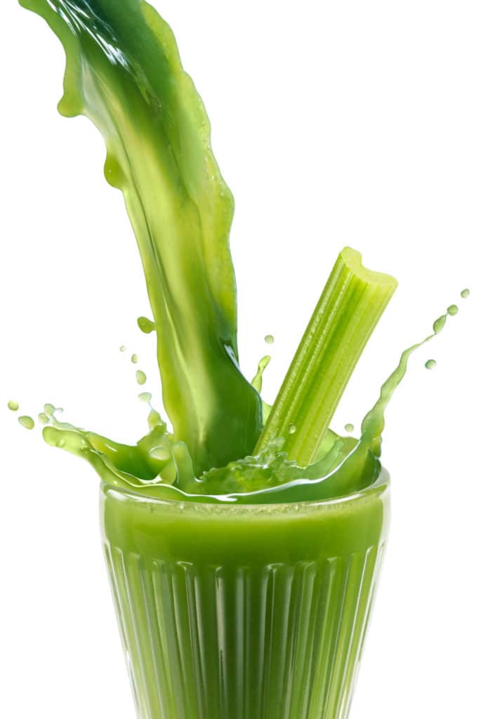 celery juice splashing into a cup