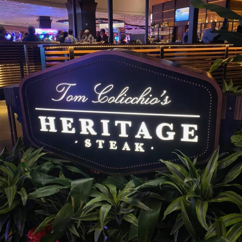 sign outside of Tom Colicchio's Heritage Steak surrounded by plants
