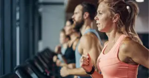 several people running on treadmills in front of a window