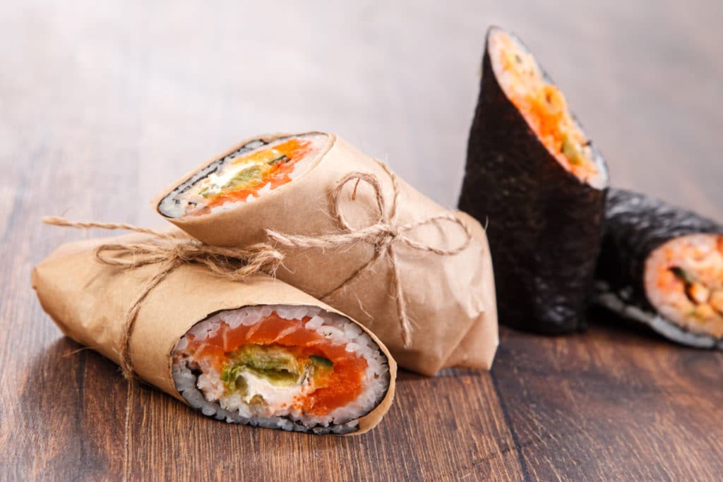 several sushi burritos wrapped in paper