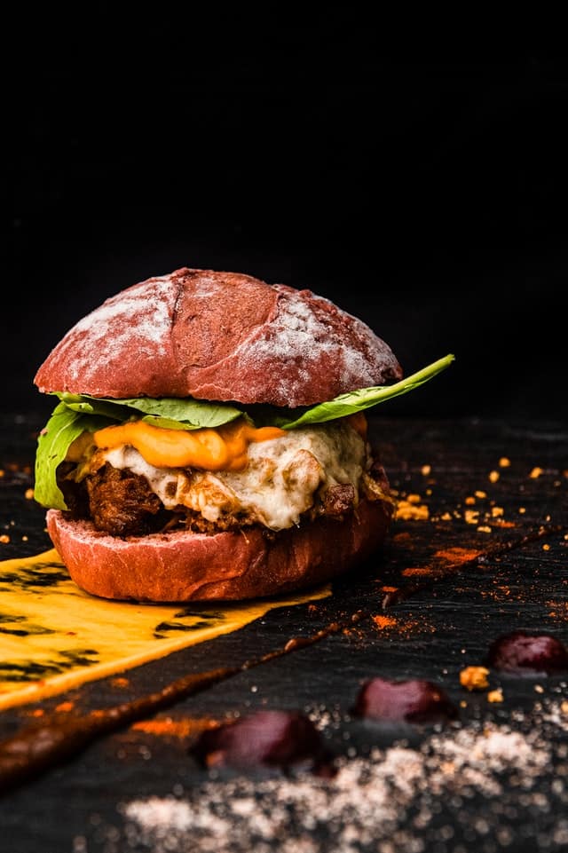 Burger on a wooden board with black background