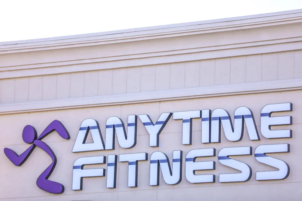 AnyTime fitness sign on a tan wooden building front