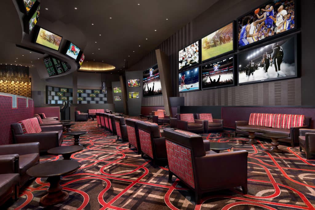 red and brown chairs facing TV screens At ARIA sportsbook
