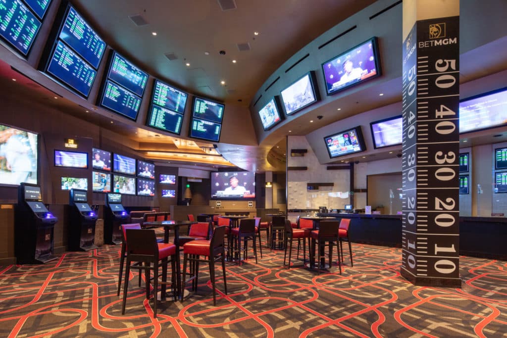 oddsboard at ARIA casino with high top tables and chairs
