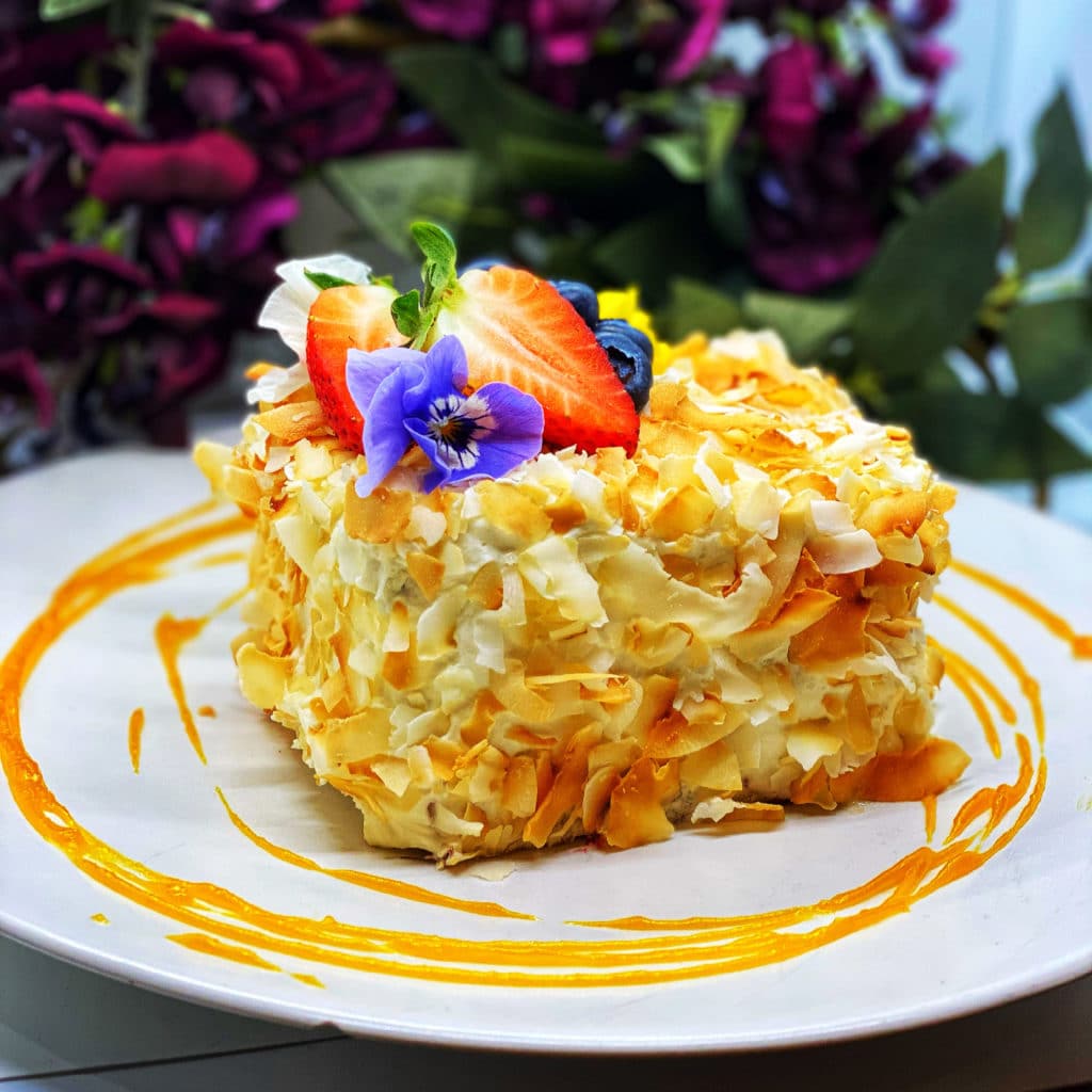 a yellow egg dessert with strawberries and flowers