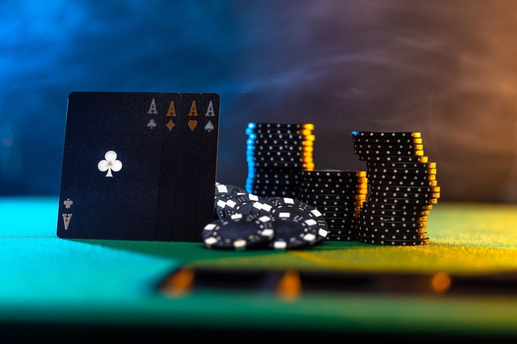 black cards with black chips set with mood lighting on a poker table