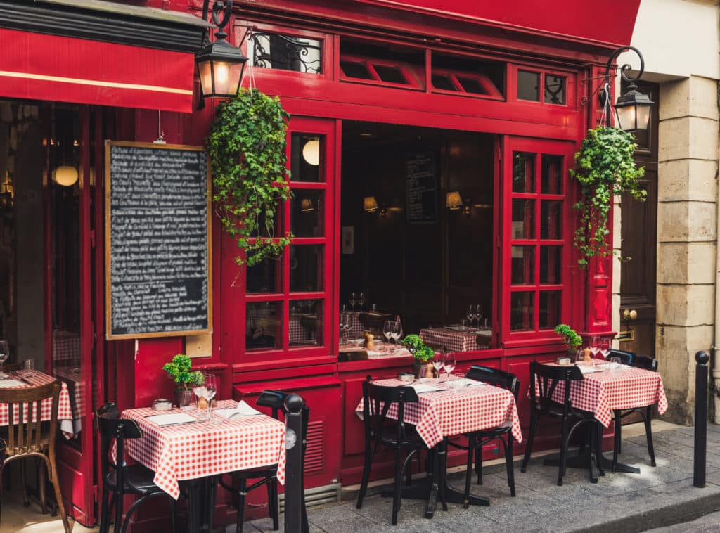 a French restaurant with red walls and checkered tablecloths