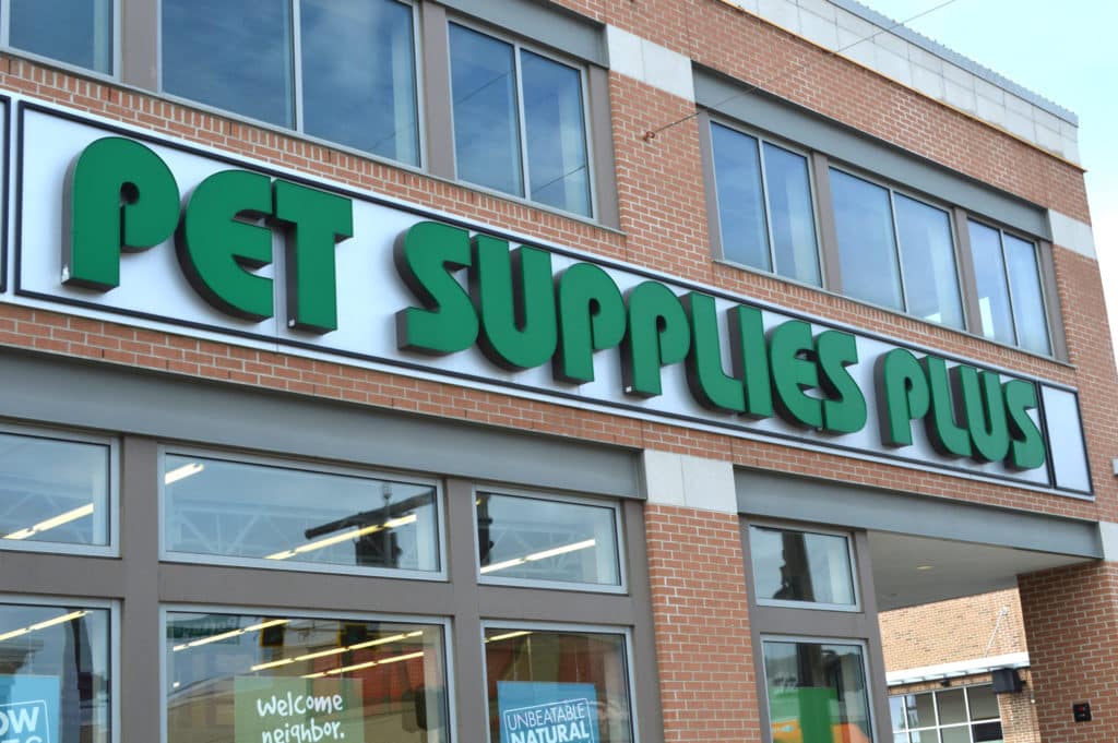 a green Pet Supplies Plus sign on a brick building