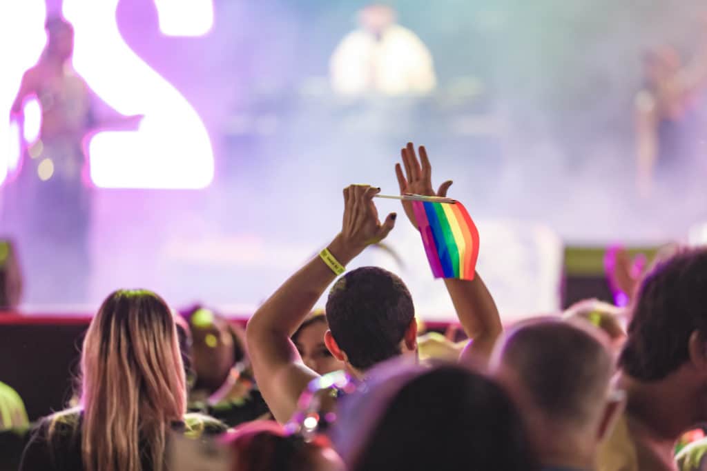 man holding a rainbow flag at a concert in Las Vegas
