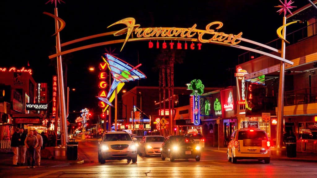 night shot of Fremont Street Experience sign with cars and a red hue