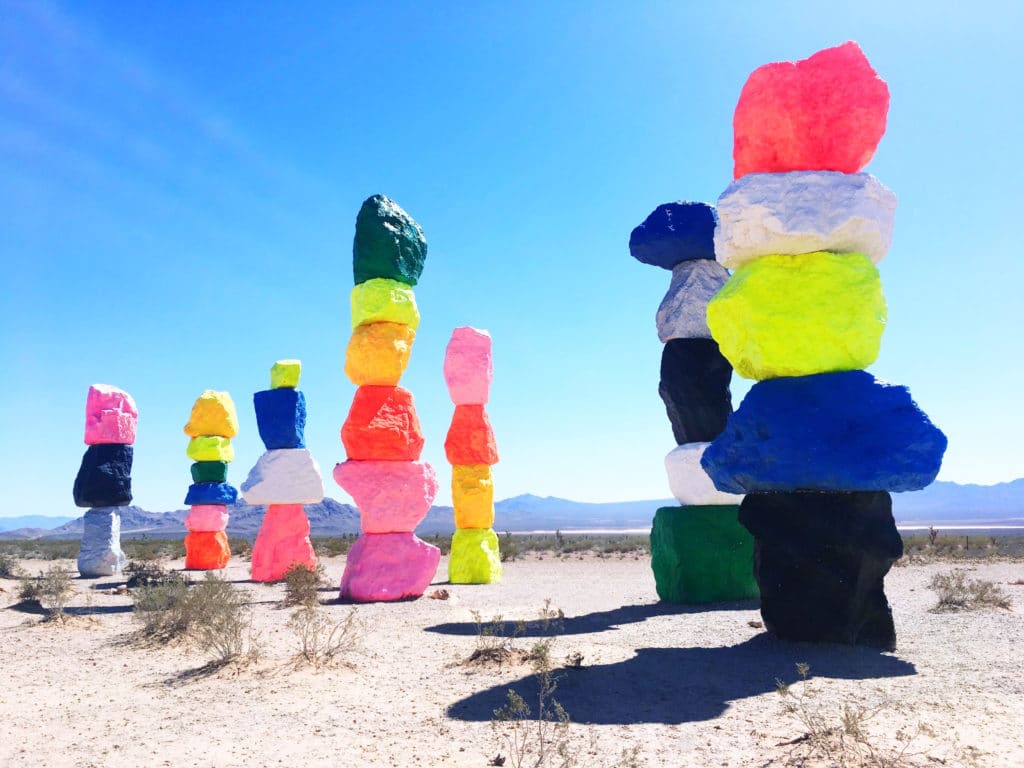 Seven Magic Mountains during the day set against white sand