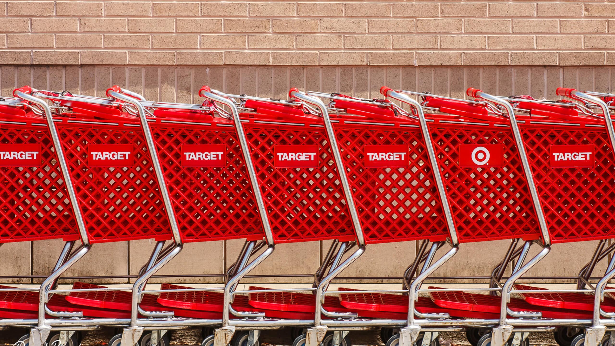 a row of carts at Target against a brick wall
