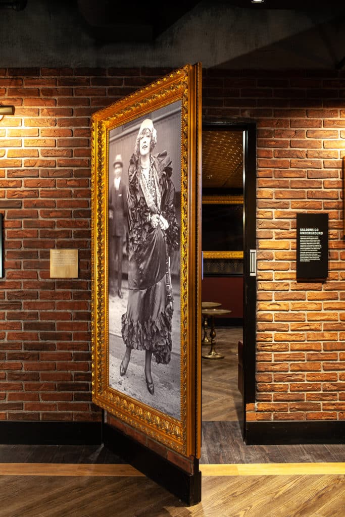 a floor-to-ceiling picture frame with a flapper girl opening to reveal the secret bar at the Vegas Mob Museum