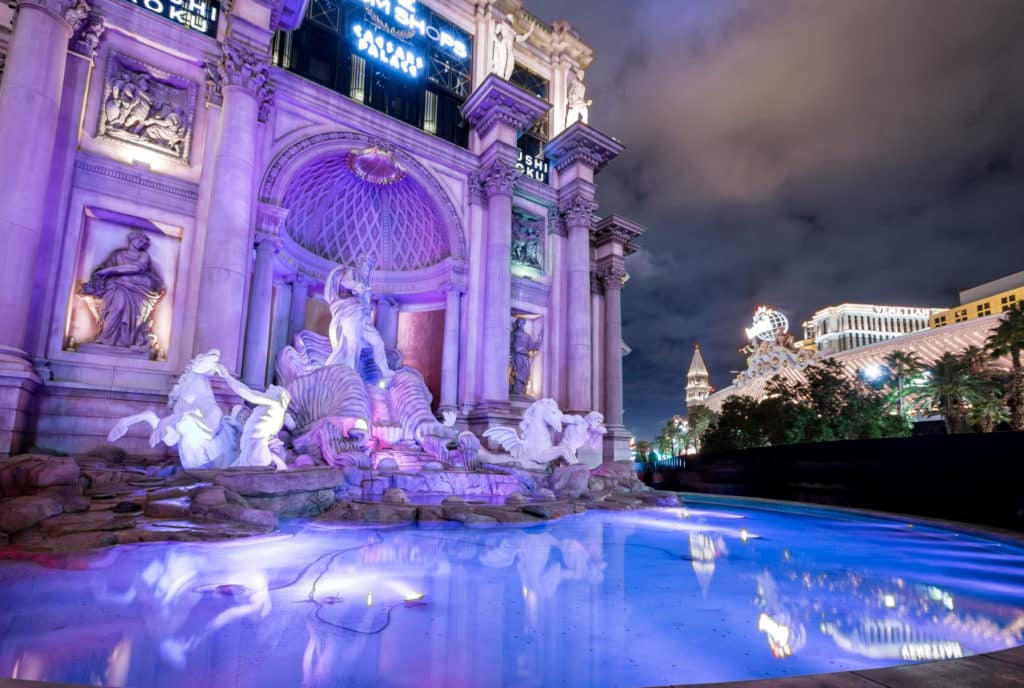 Night view of Trevi Fountains at Caesars Palace with purple hues and blue water