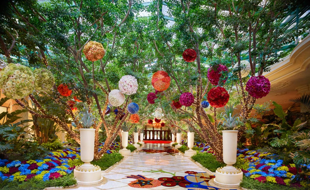 Wynn atrium with trees and light baubles against a white marble backdrop