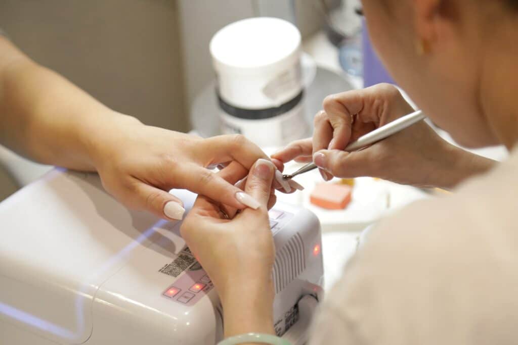 A nail technician performs a procedure on a client in Las Vegas