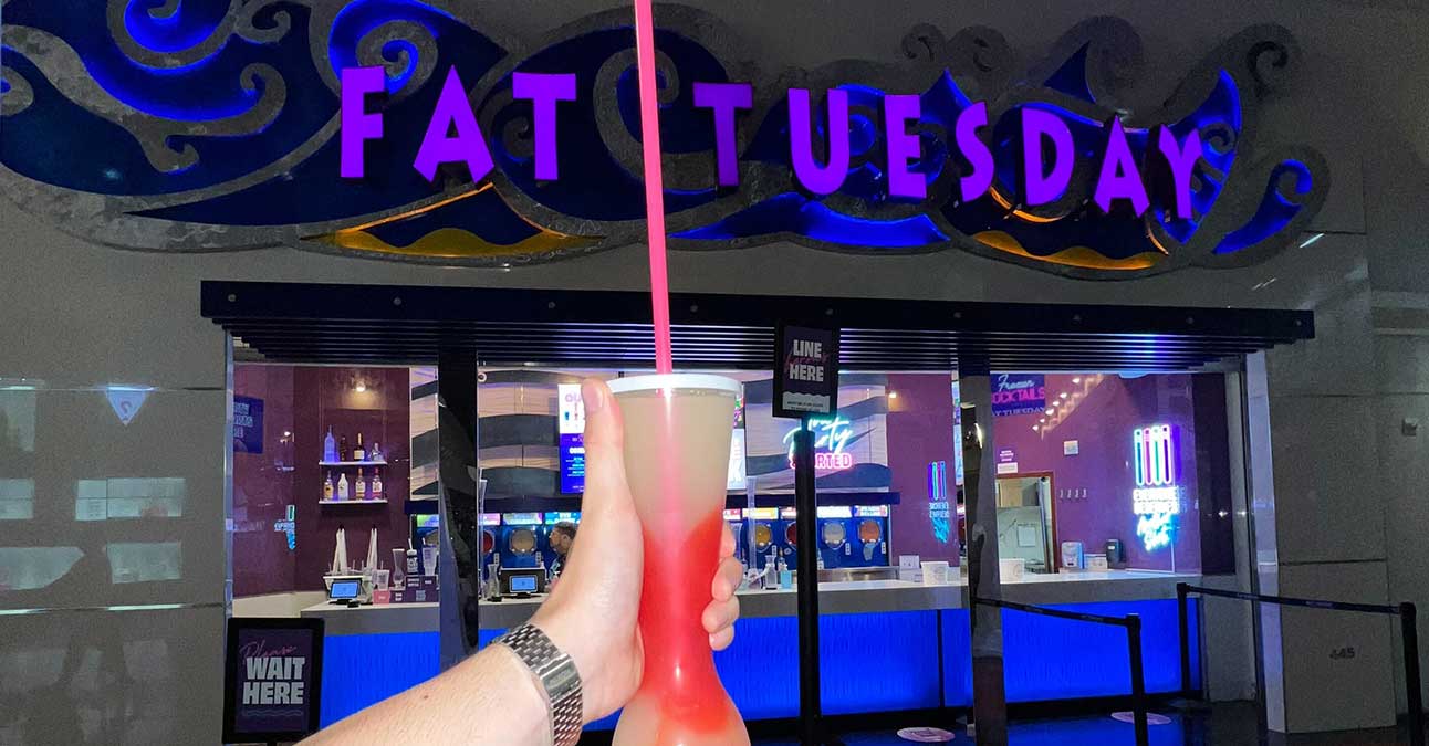 a woman holding a drink in front of Fat Tuesdays Las Vegas