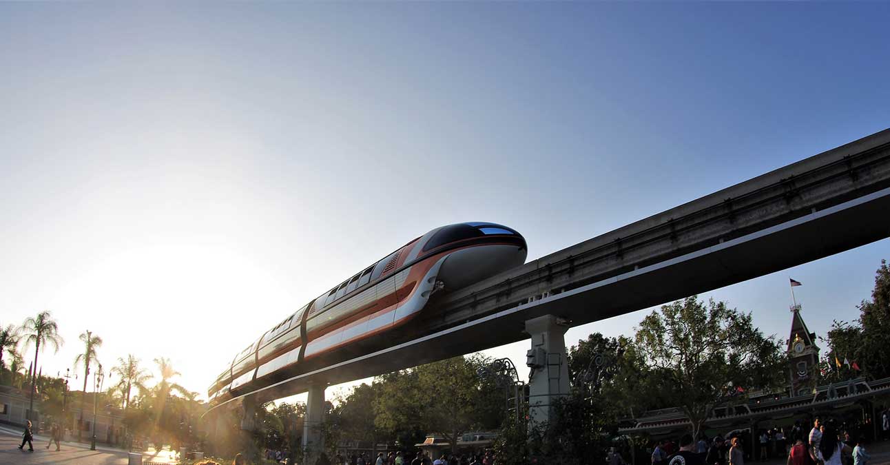 A monorail high up in front of a low sun