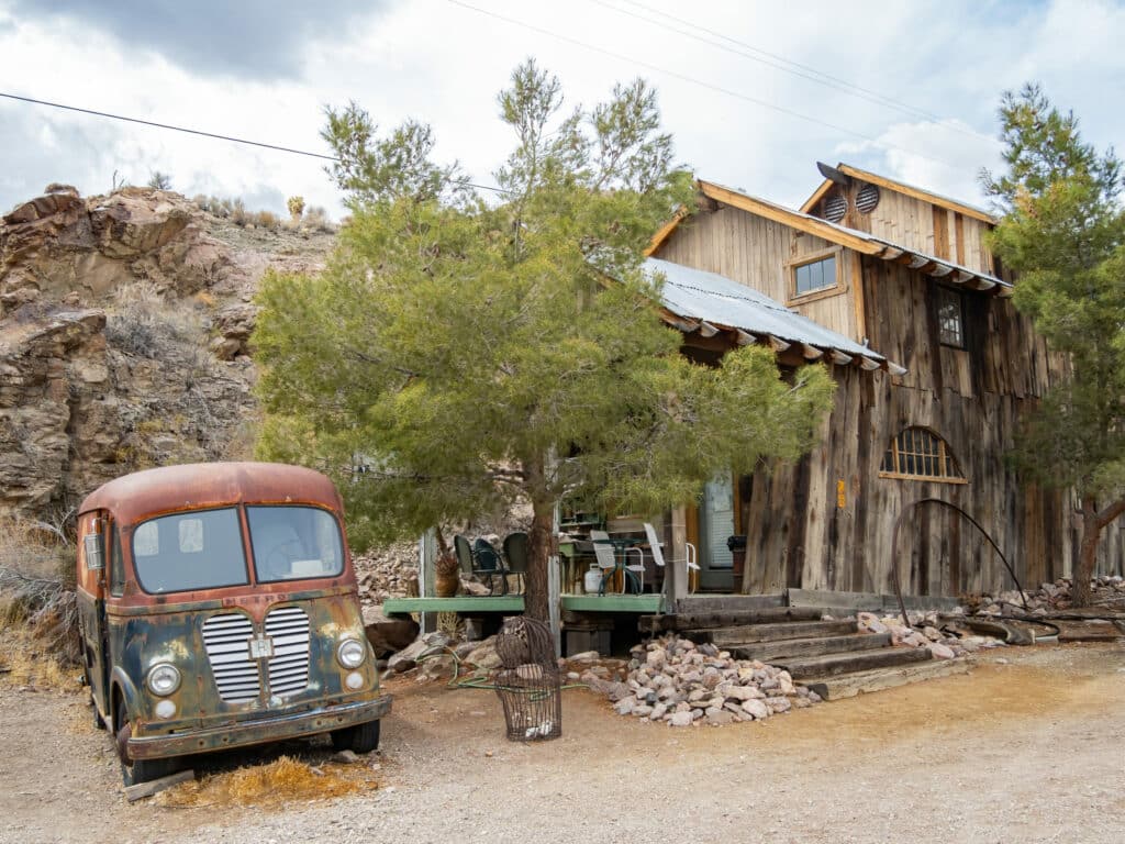 an abandoned car next to a building at Nelson's Ghost Town