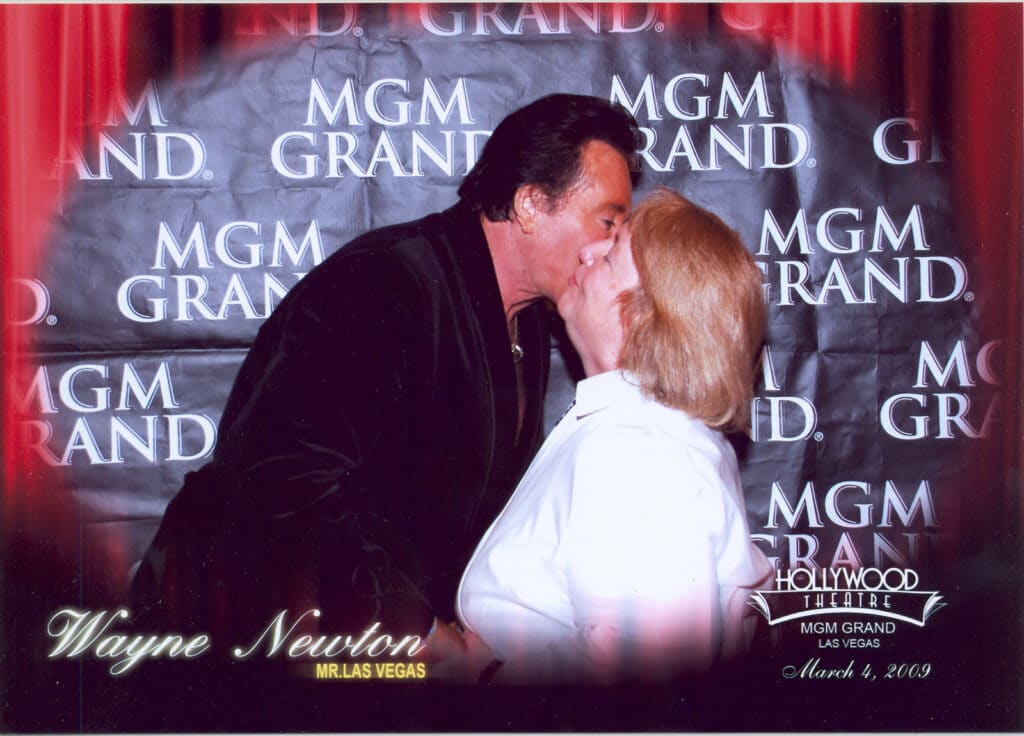 Wayne Newton kissing a female fan on the cheek