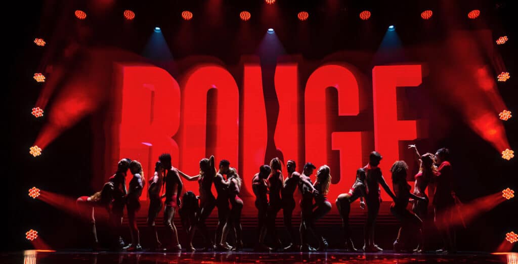 actors set against red backdrop of Rouge burlesque show