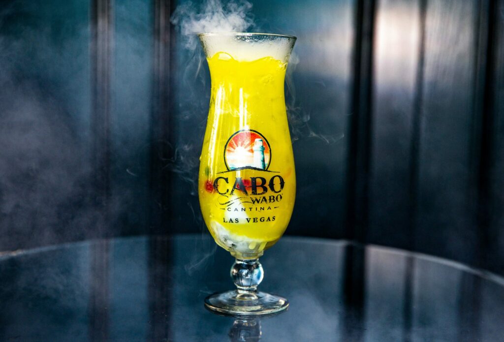 a yellow tall cocktail with Cabo Wabo Cantina on it